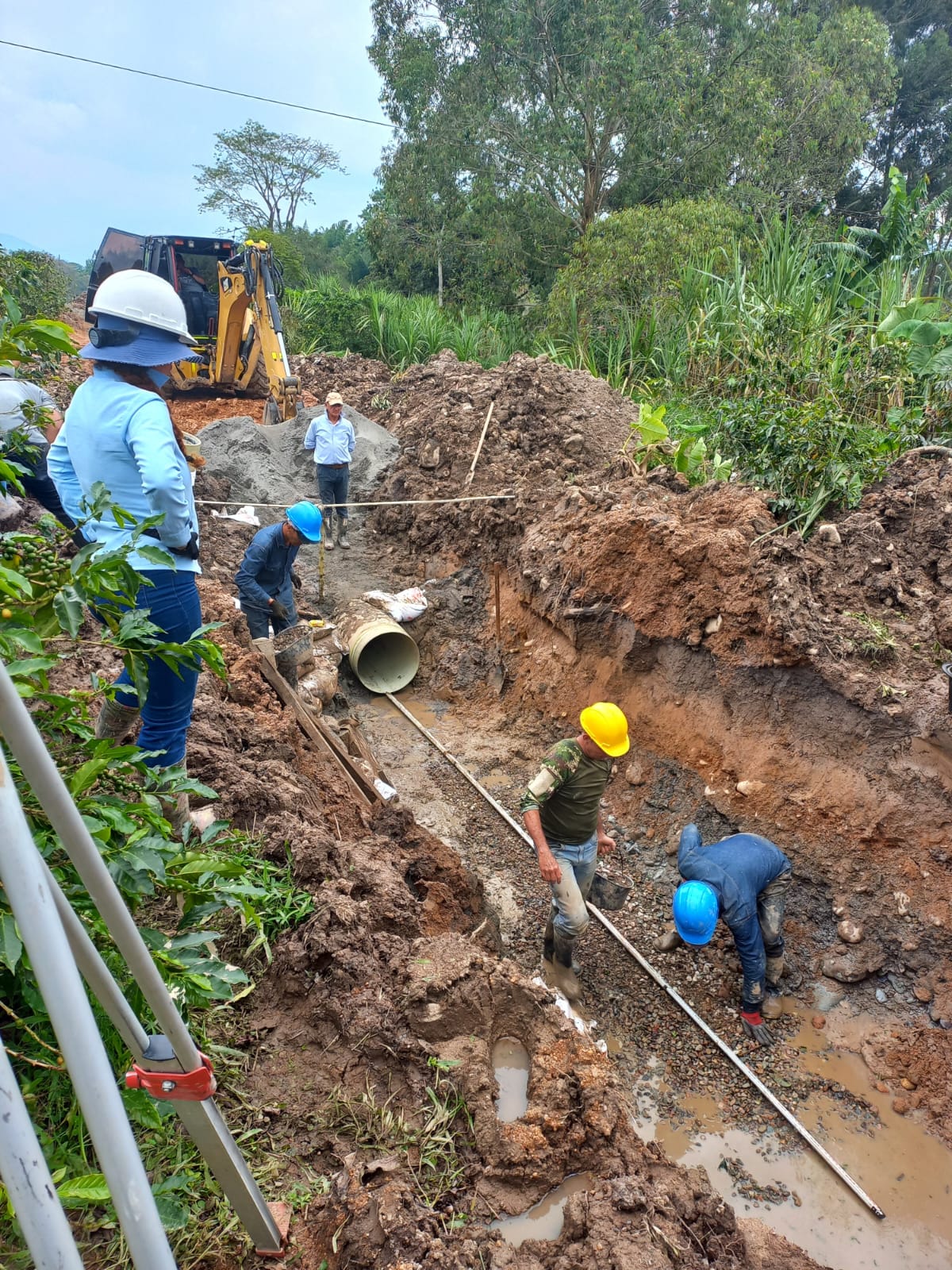 Cuadrilla instalando tubería en una zanja de acueducto