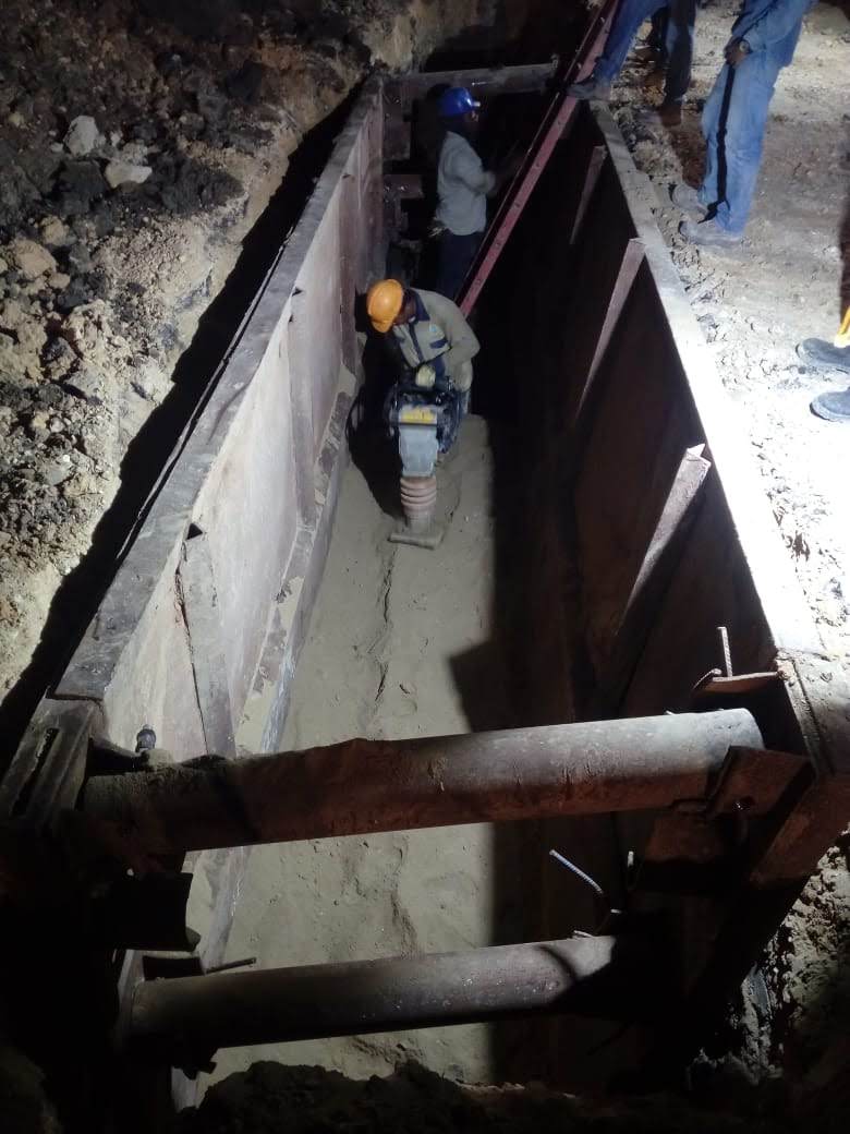 Trabajador compactando terreno en una zanja de acueducto