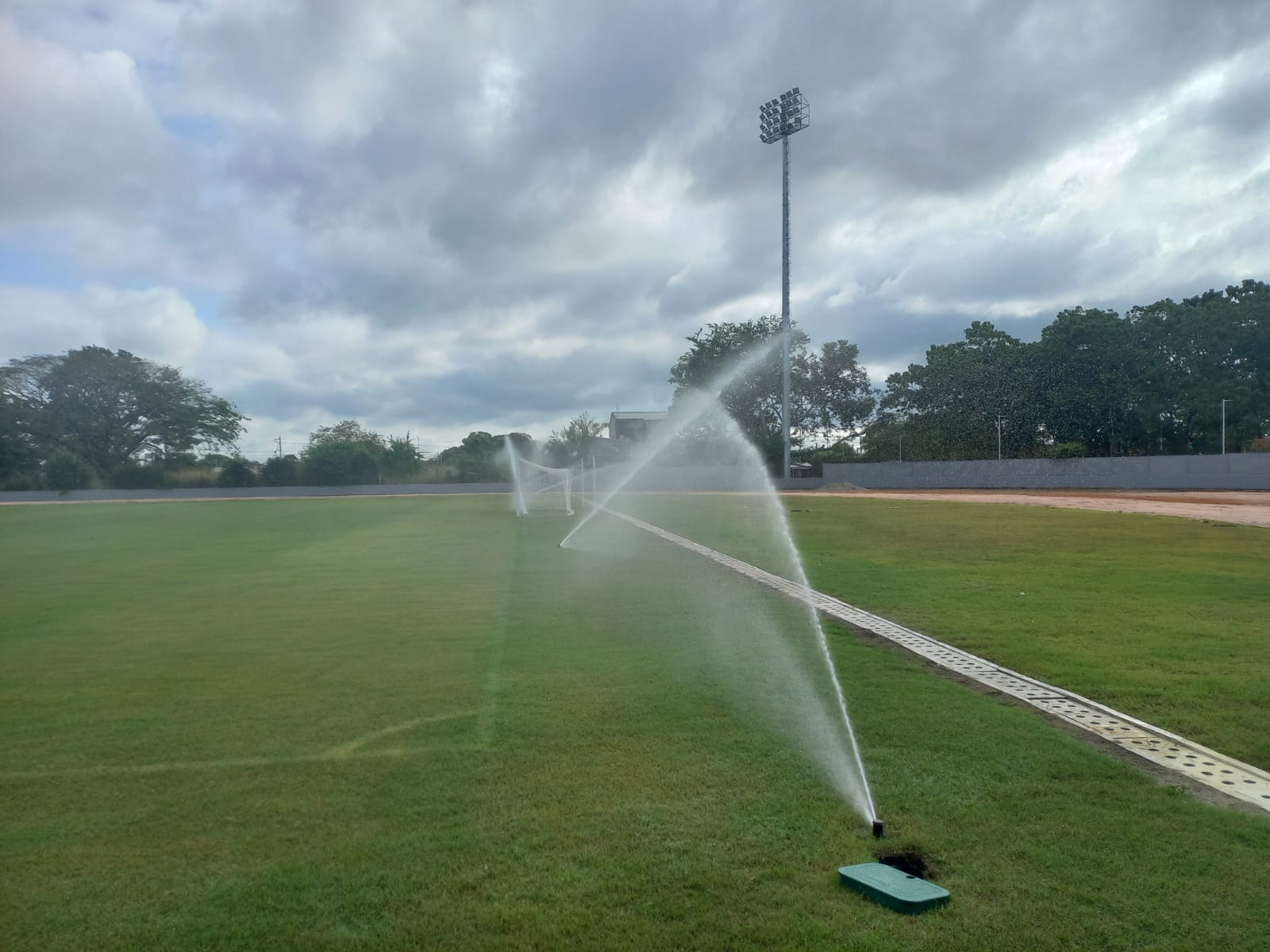 Sistema de riego funcionando en la cancha de un escenario deportivo