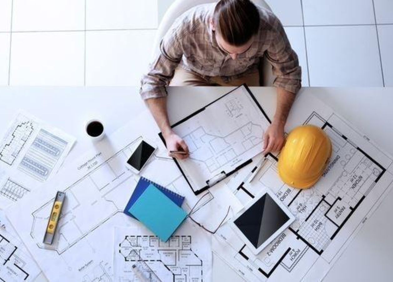 Ingeniero de CMAA revisando planos de un proyecto